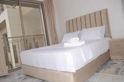 a bedroom with a large white bed with a mirror at Luxury apartment fully furnished in Casablanca