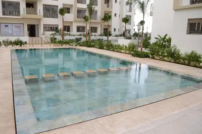 a swimming pool in the middle of a building at New Luxury apartment 5 min Casablanca Mohammed V Airport in Casablanca
