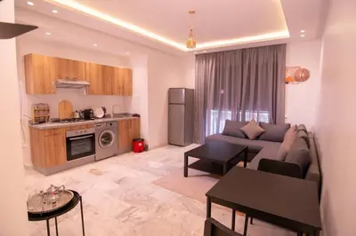 a living room with a couch and a kitchen at New Luxury apartment 5 min Casablanca Mohammed V Airport in Casablanca