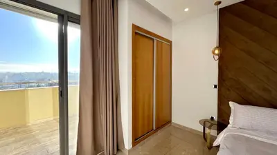a bedroom with a bed and a large window at The building of Terrazas 34 - By AppartAli in Casablanca