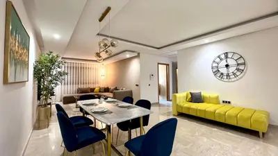 a living room with a dining table and a yellow couch at The building of Terrazas 34 - By AppartAli in Casablanca