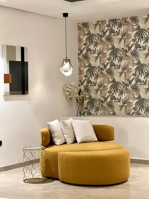 a yellow couch in a living room with a wall at La Vida est Magnifique - 3 Chambres in Casablanca