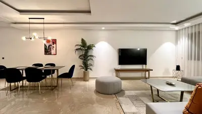 a living room with a table and a tv at La Vida est Magnifique - 3 Chambres in Casablanca