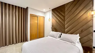 a bedroom with a white bed and a wooden headboard at Marvelous Center Spot - 3 Bedrooms in Casablanca