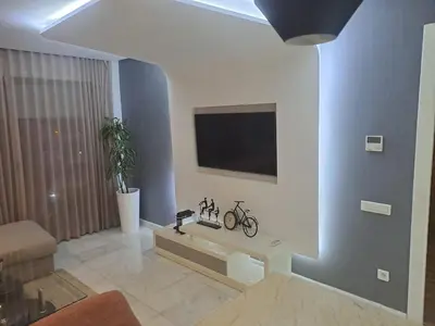 a living room with a tv on a wall with two bikes on it at Studio ALMASSIRA in Casablanca