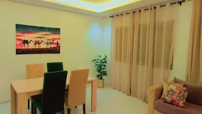 a living room with a dining room table and a couch at Appartement Perla - Costa Bouznika in Bouznika
