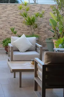 a couch and a table on a patio with plants at Nassali - Luxurious Beachfront Villa with Private Pool in Casablanca