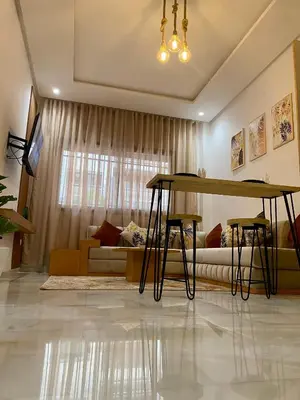 a living room with a table and a couch at Élégance en 40 mètres Nouaceur in Nouaceur