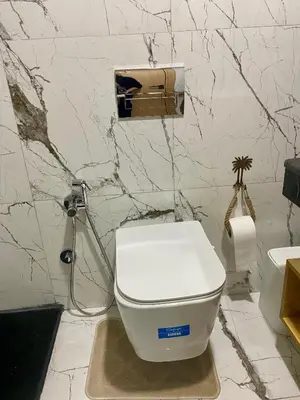 a white toilet in a bathroom with marble walls at Élégance en 40 mètres Nouaceur in Nouaceur