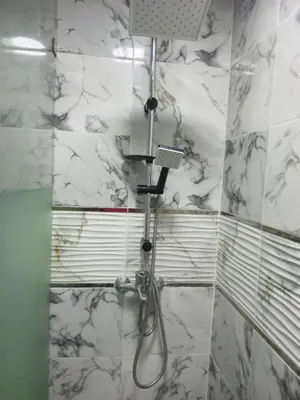 a shower in a bathroom with white marble walls at Studio Zenith in Casablanca