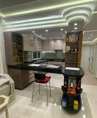 a kitchen with a black counter and a red chair at Appartement spacieux et moderne in Casablanca