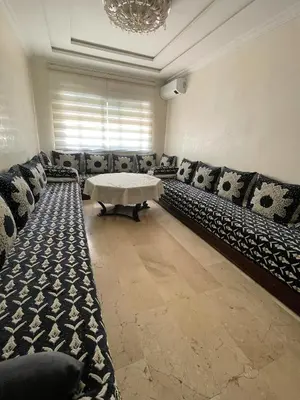 a room with couches and a table and a chandelier at Résidence Ryad Albahr Herhoura in Temara