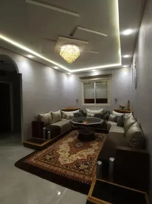 a living room with a couch and a table at Charmant appartement 15 minutes de la plage in Mohammedia