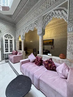 a living room with a pink couch and a table at Riad Blue Garden in Rabat