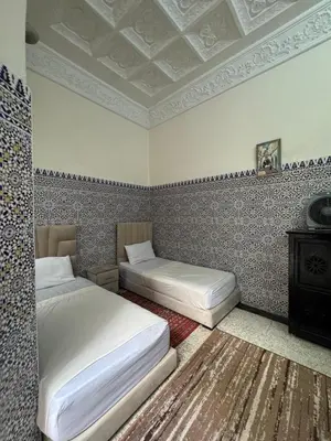 a bedroom with two beds and a coffered ceiling at Riad Blue Garden in Rabat