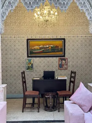 a living room with a couch and a table and chairs at Riad Blue Garden in Rabat