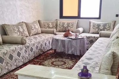 a living room with a couch and a table at Rooms in shared apartment close to CMN-Airport in Dah Hammou Ben Cheïkh