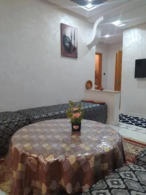 a room with a table with a vase of flowers on it at Rooms in shared apartment close to CMN-Airport in Dah Hammou Ben Cheïkh