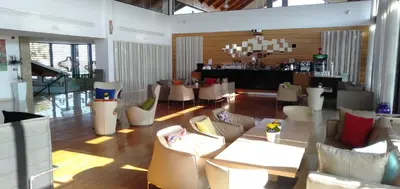 a lobby with couches and tables and a bar at Bahia Golf Beach Bouznika appart in Bouznika