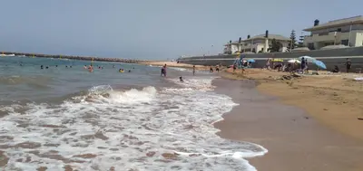 a group of people in the water at a beach at Bahia Golf Beach Bouznika appart in Bouznika