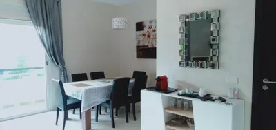 a dining room with a table and chairs and a mirror at Bahia Golf Beach Bouznika appart in Bouznika