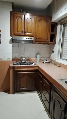 a kitchen with wooden cabinets and a stove top oven at tranquil harmony in Casablanca