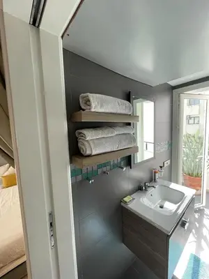 a bathroom with a sink and a mirror and towels at Central, terrasse, confortable - Bleue résidence in Casablanca