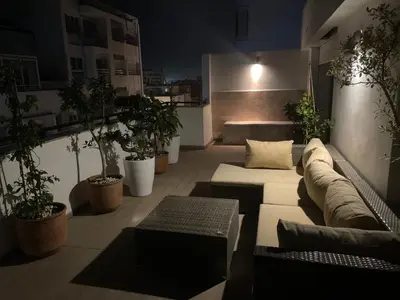a living room with couches and potted plants at Central, terrasse, confortable - Bleue résidence in Casablanca