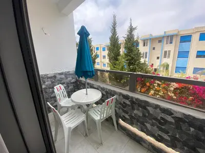a balcony with a table and chairs and an umbrella at Marbella beach appart de standing in Mansouria