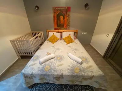 a bedroom with a bed with flowers on it at Marbella beach appart de standing in Mansouria