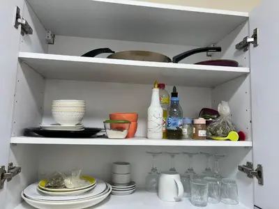 a kitchen cabinet filled with dishes and bowls and plates at Dar MAKTOUBE in Mohammedia