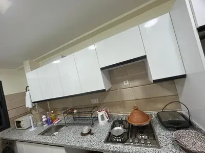 a kitchen with white cabinets and a stove top oven at Dar MAKTOUBE in Mohammedia