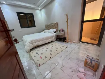 a bedroom with a bed and a rug on the floor at Dar MAKTOUBE in Mohammedia