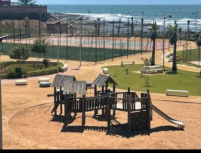 a park with a playground with a slide at Bel appartement pieds sur mer in Casablanca