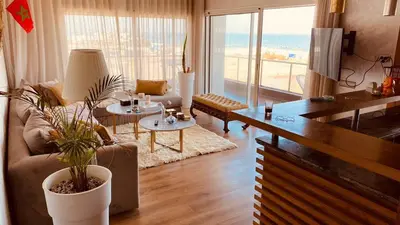a living room with a couch and a table at Bel appartement pieds sur mer in Casablanca