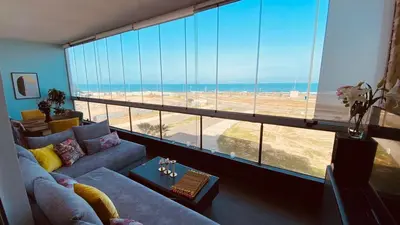 a living room with a large window with a view of the beach at Bel appartement pieds sur mer in Casablanca