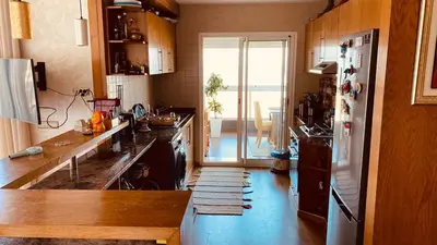 a kitchen with a sink and a refrigerator at Bel appartement pieds sur mer in Casablanca