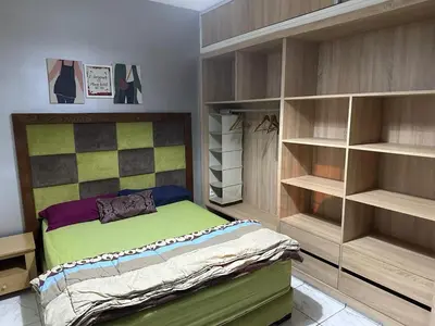 a bedroom with a bed and some shelves at Apparemment TAMARIS in Dar Bouazza