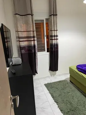 a room with a bed and a desk and a window at Apparemment TAMARIS in Dar Bouazza