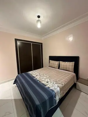 a bedroom with a large bed with a blue blanket at Appartement propre 2 Chambres in Casablanca