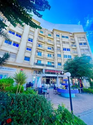 a large building with tables and chairs in front of it at CASA Ghandi Central Apart 1Ch salon in Casablanca