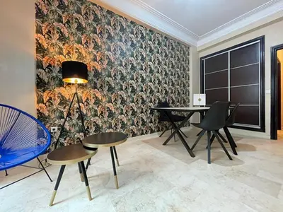 a dining room with a table and chairs and a wall mural at Un bijou d'élégance au coeur du quartier Racine de Casablanca in Casablanca