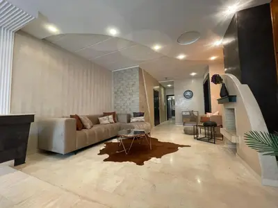 a living room with a couch and a table at Un bijou d'élégance au coeur du quartier Racine de Casablanca in Casablanca
