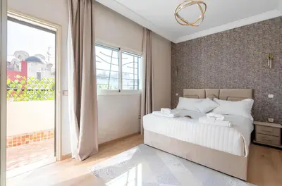a bedroom with a large bed and a large window at Spacieux appartement 80 m² - Centre de Casablanca in Casablanca