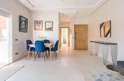 a dining room with a table and blue chairs at Spacieux appartement 80 m² - Centre de Casablanca in Casablanca