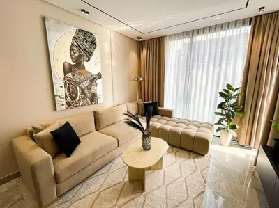 a living room with a couch and a table at Modern Studio with Balcony & Parking Les Princesses 204 in Casablanca