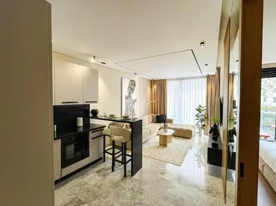 a room with a kitchen and a living room at Modern Studio with Balcony & Parking Les Princesses 204 in Casablanca