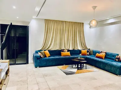 a living room with a blue couch and a table at Cosy 80 m2 with 2 balcony 5min Hassan 2 in Casablanca