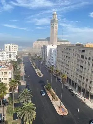 a city with a clock tower and a street with buildings at Cosy 80 m2 with 2 balcony 5min Hassan 2 in Casablanca