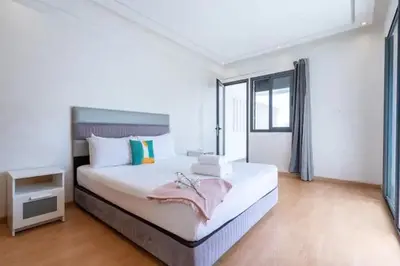 a bedroom with a large white bed with a window at Cosy 80 m2 with 2 balcony 5min Hassan 2 in Casablanca